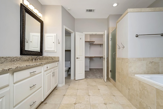 full bath with a garden tub, toilet, vanity, visible vents, and a stall shower