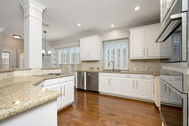 kitchen featuring a wealth of natural light, dark hardwood / wood-style floors, white cabinetry, and hanging light fixtures