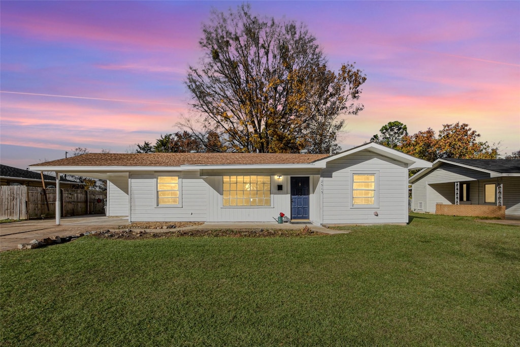 single story home with a carport and a lawn