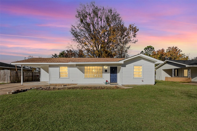 ranch-style house featuring a yard and a carport