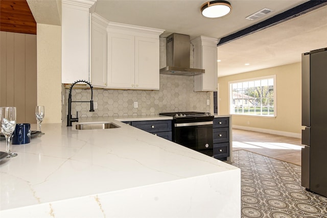 details featuring wooden walls, tasteful backsplash, white cabinetry, sink, and light stone countertops