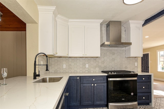 kitchen with wall chimney range hood, sink, backsplash, white cabinets, and stainless steel range with gas cooktop