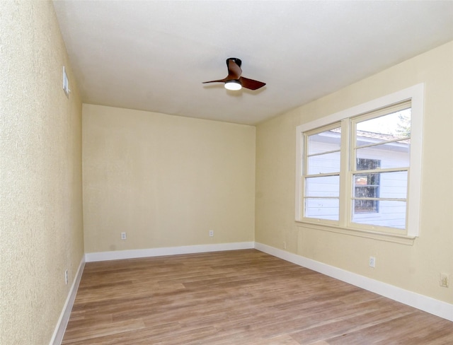 empty room with ceiling fan and light wood-type flooring