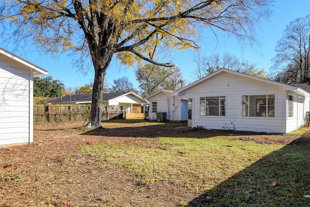 exterior space with central AC and a lawn