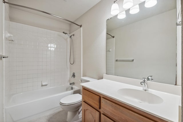 full bathroom with vanity, tile patterned flooring, tiled shower / bath, and toilet