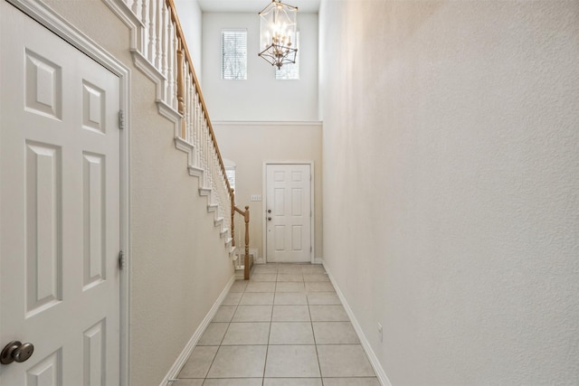 doorway to outside featuring a chandelier and light tile patterned flooring