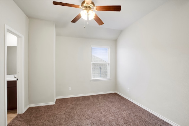 carpeted empty room featuring ceiling fan, sink, and vaulted ceiling