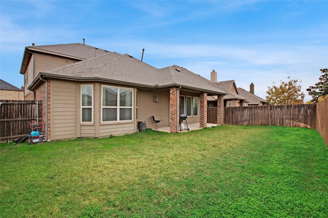 back of property with a yard and a patio area