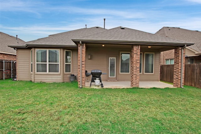 back of house featuring a lawn and a patio