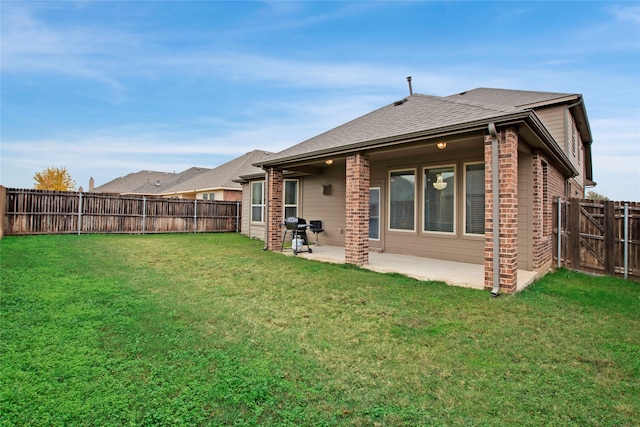 back of house featuring a patio area and a yard