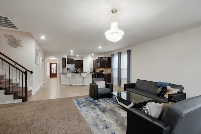 living room with light carpet and a notable chandelier