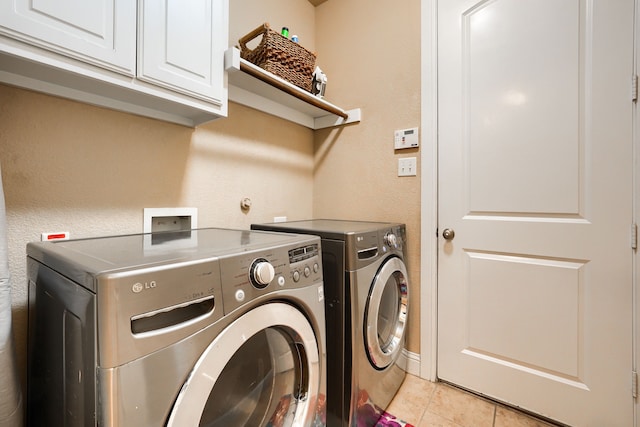 washroom with independent washer and dryer, cabinets, and light tile patterned floors