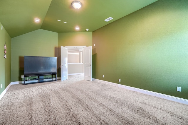 unfurnished living room with vaulted ceiling and carpet floors