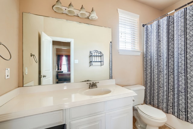 bathroom featuring walk in shower, vanity, and toilet