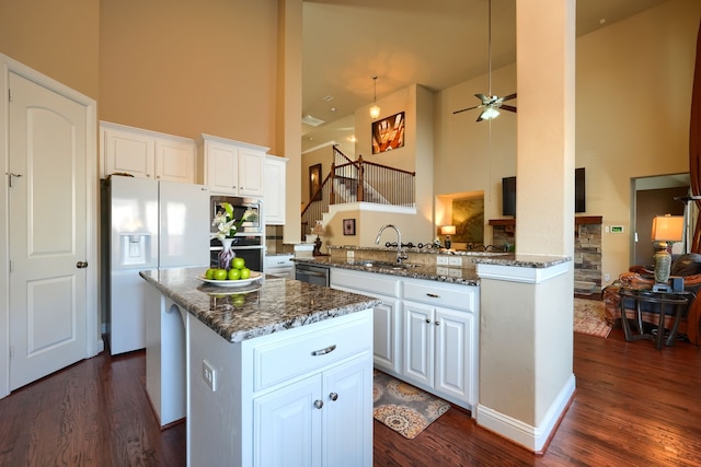 kitchen with sink, white cabinetry, a center island, kitchen peninsula, and stainless steel appliances