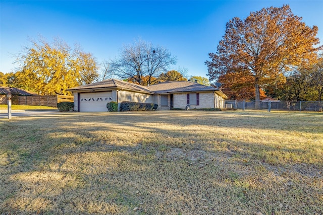 ranch-style home with a garage and a front lawn