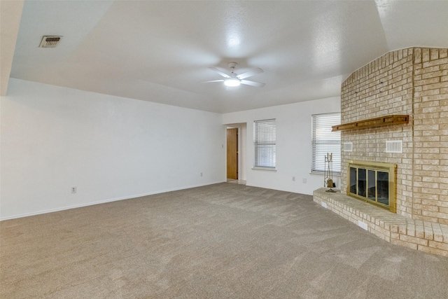 unfurnished living room featuring carpet, a brick fireplace, vaulted ceiling, and ceiling fan