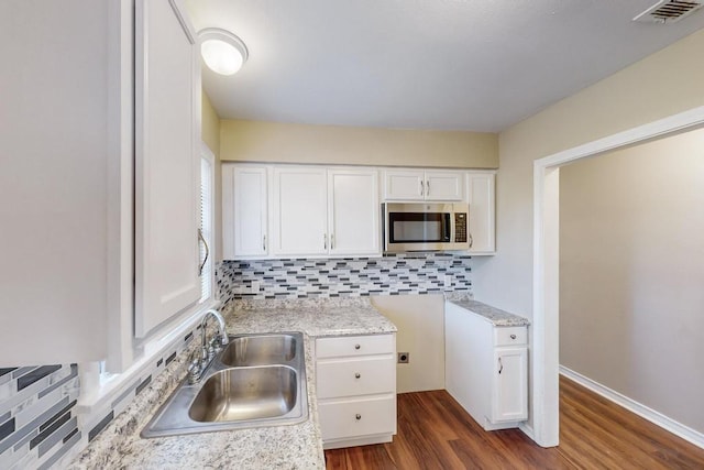 kitchen featuring white cabinetry, sink, backsplash, and dark hardwood / wood-style floors