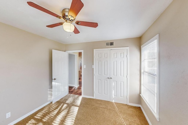 unfurnished bedroom with carpet floors, a closet, and ceiling fan