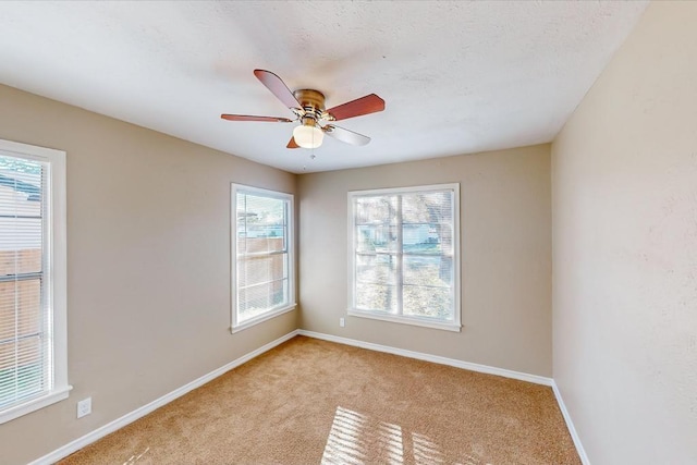 unfurnished room featuring ceiling fan, light colored carpet, and a textured ceiling