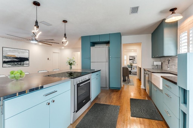 kitchen with sink, backsplash, light hardwood / wood-style floors, blue cabinetry, and white appliances