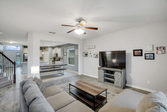 living room featuring hardwood / wood-style floors and ceiling fan