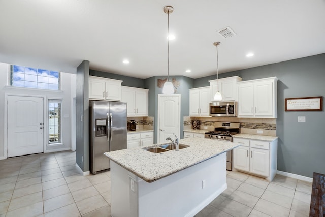 kitchen with sink, stainless steel refrigerator with ice dispenser, pendant lighting, a kitchen island with sink, and white cabinets