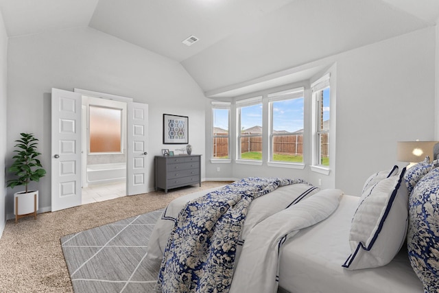 carpeted bedroom featuring ensuite bathroom and vaulted ceiling