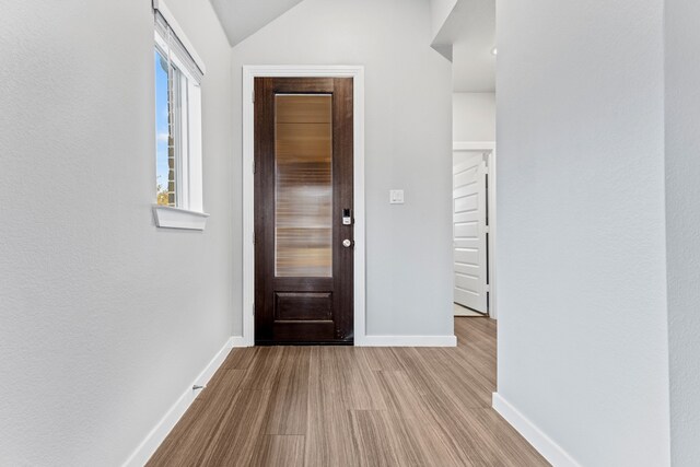 foyer featuring lofted ceiling and light wood-type flooring