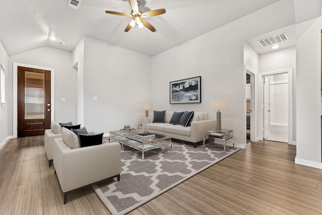 living room with hardwood / wood-style flooring, ceiling fan, and vaulted ceiling