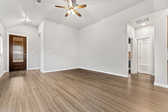 unfurnished living room with ceiling fan, lofted ceiling, and wood-type flooring