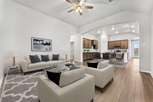 living room featuring light wood-type flooring, ceiling fan, and lofted ceiling