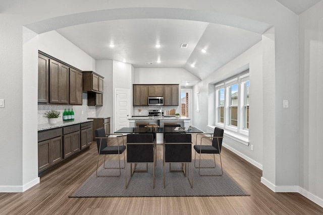 dining space with dark hardwood / wood-style floors and lofted ceiling