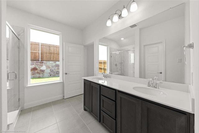 bathroom with tile patterned flooring, vanity, and walk in shower