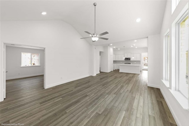 unfurnished living room with dark hardwood / wood-style floors, ceiling fan, and high vaulted ceiling