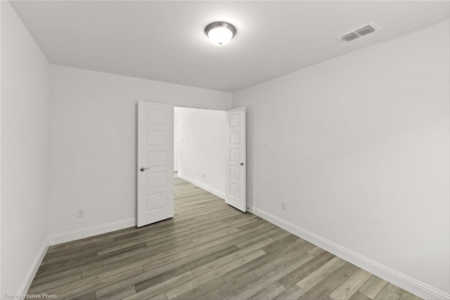 unfurnished room with hardwood / wood-style flooring