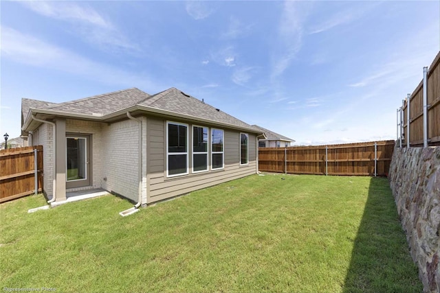 rear view of property featuring a lawn