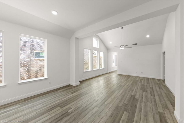 unfurnished living room with ceiling fan, plenty of natural light, light hardwood / wood-style floors, and vaulted ceiling