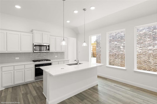 kitchen with white cabinetry, light hardwood / wood-style flooring, stainless steel appliances, and decorative light fixtures