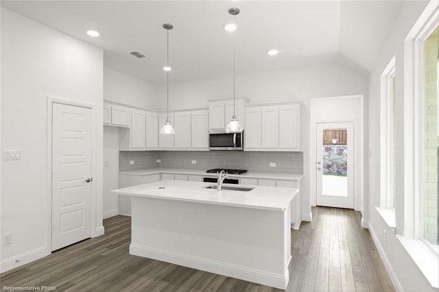 kitchen featuring sink, tasteful backsplash, dark hardwood / wood-style flooring, an island with sink, and white cabinets