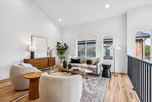 living room featuring light wood-type flooring and high vaulted ceiling