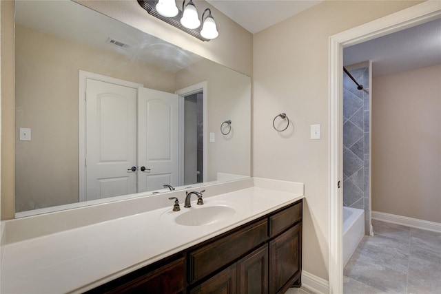 bathroom featuring tile patterned flooring, vanity, and  shower combination