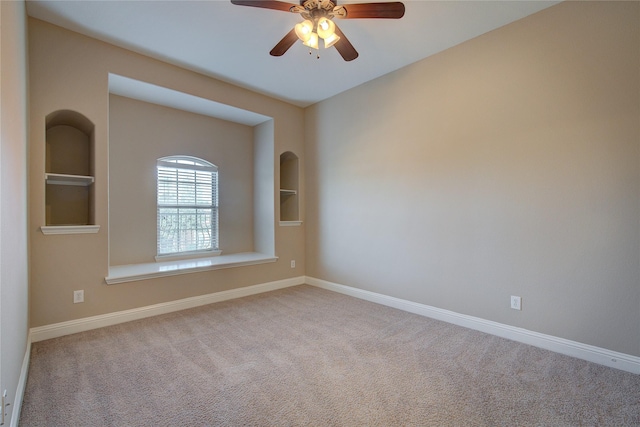 carpeted empty room featuring built in features and ceiling fan