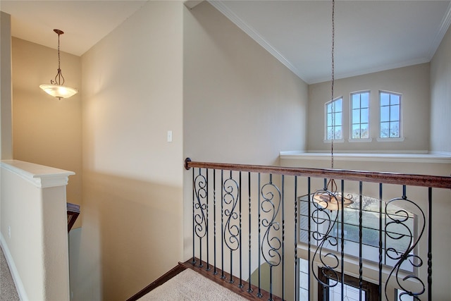 corridor featuring crown molding, baseboards, carpet floors, and an upstairs landing