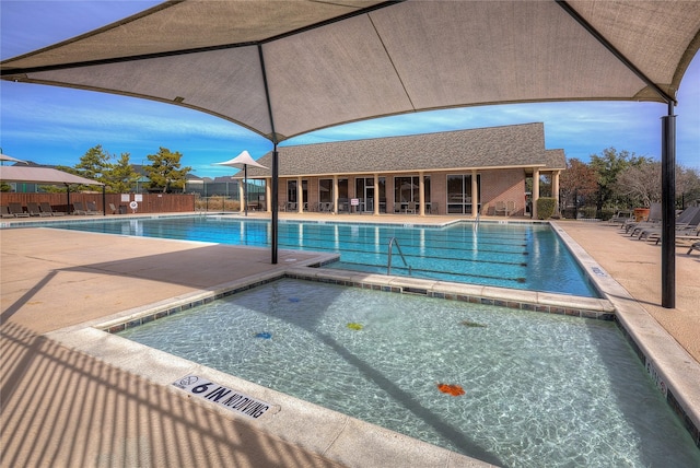 community pool with a community hot tub, a patio area, and fence