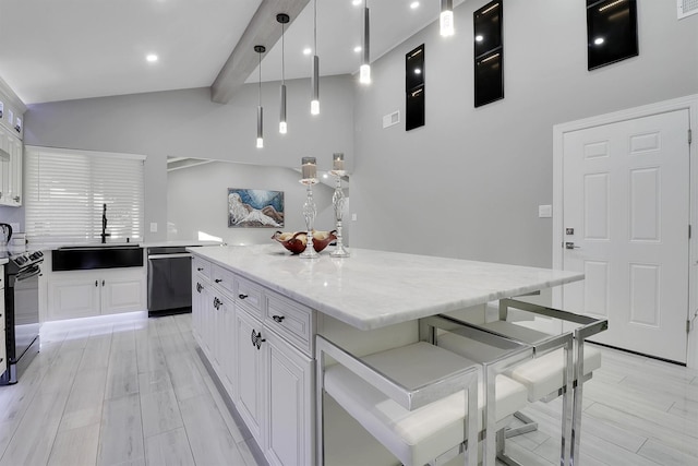 kitchen with dishwasher, white cabinets, sink, light hardwood / wood-style floors, and a kitchen island