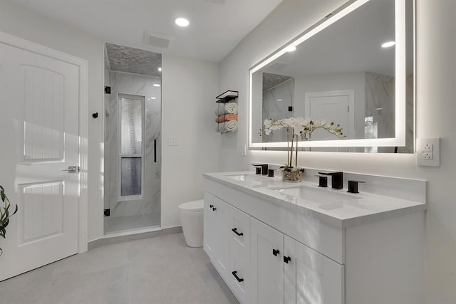 bathroom featuring tile patterned flooring, vanity, toilet, and a shower with shower door