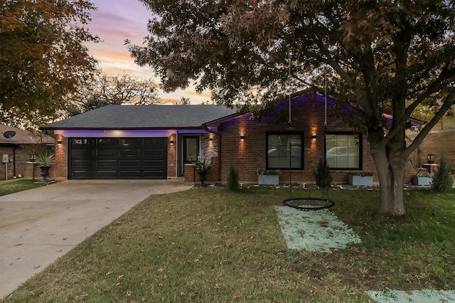 single story home featuring a garage, brick siding, a lawn, and driveway