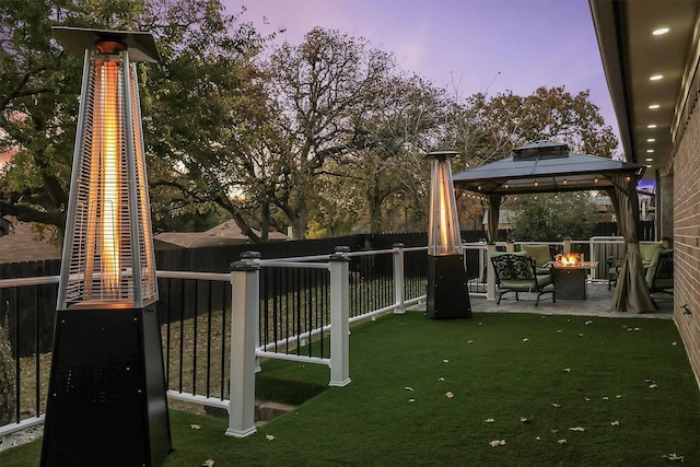 yard at dusk with a gazebo and an outdoor fire pit