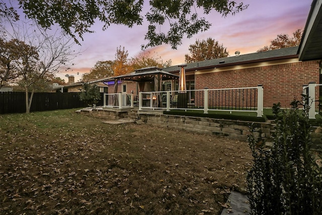 back house at dusk with a lawn